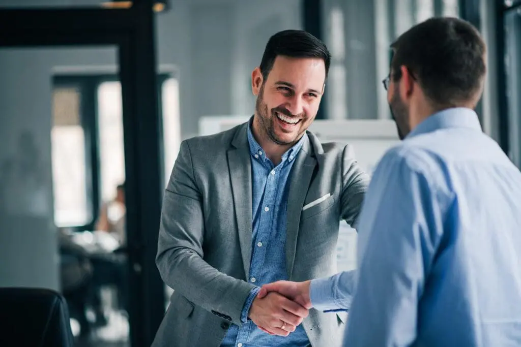A business owner greets a new employee for his homebuilder business.
