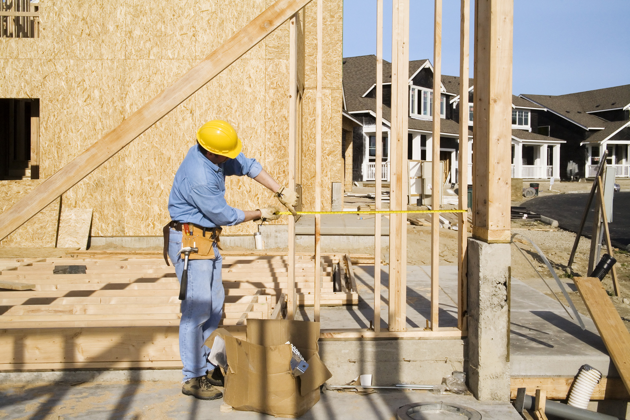 A construction worker builds a new home, impacted by homebuilding trends.