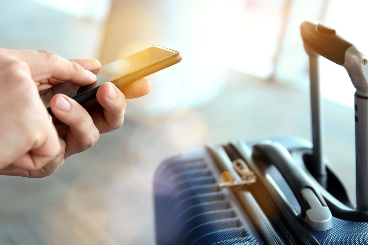 A traveler uses his phone for travel updates via conversational engagement software.