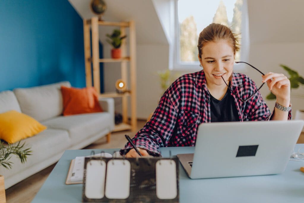 A college student on her laptop is enjoying her student experience due to conversational data used through digital assistants.
