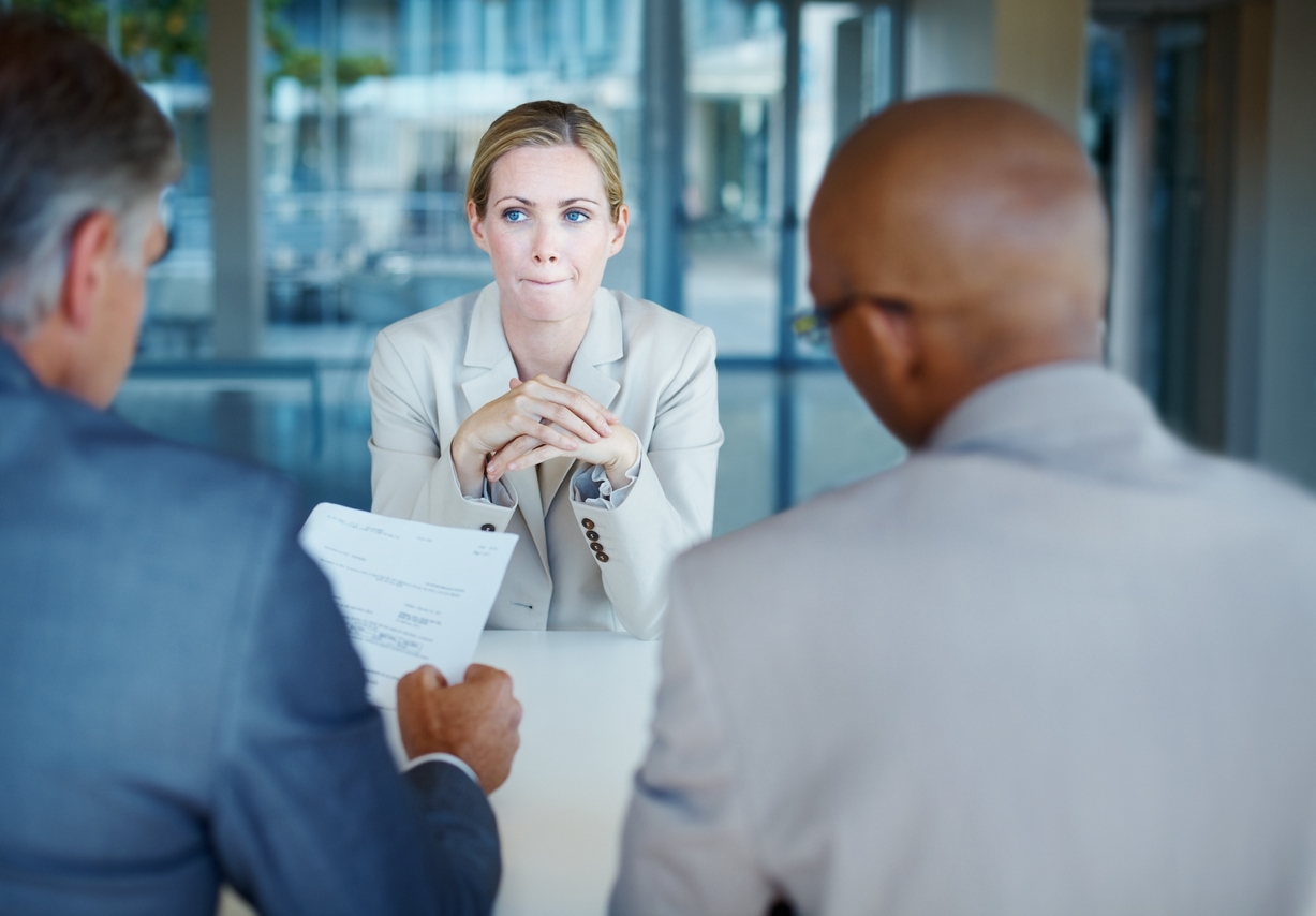 Woman frowns as she conducts an interview for a home builder sales job.