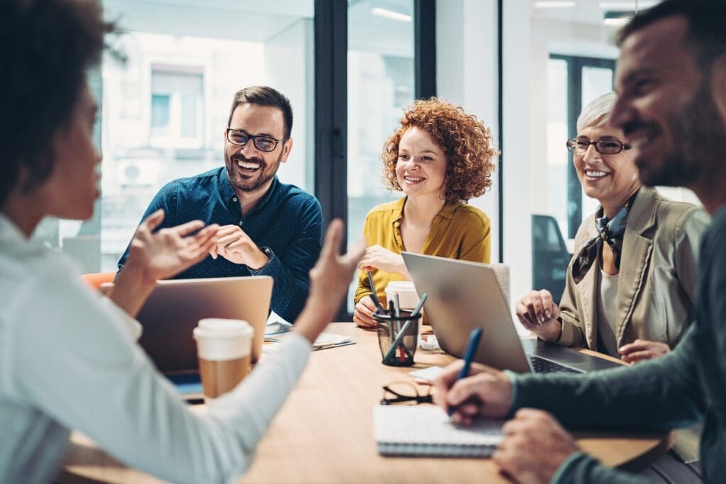 Home builder marketing agency team meets to discuss strategy around a table.