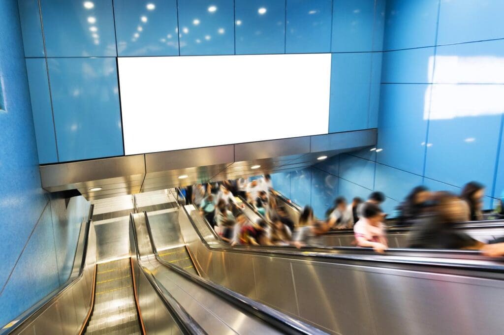 Billboard on busy escalator shows the importance of location for homebuilder signage.