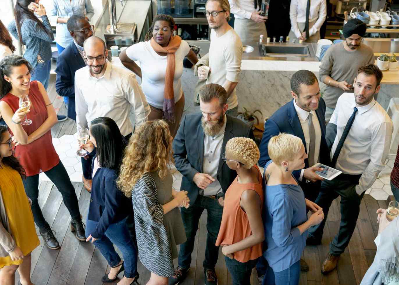 Young professionals meet at a networking event, which is part of a school’s alumni engagement strategy.