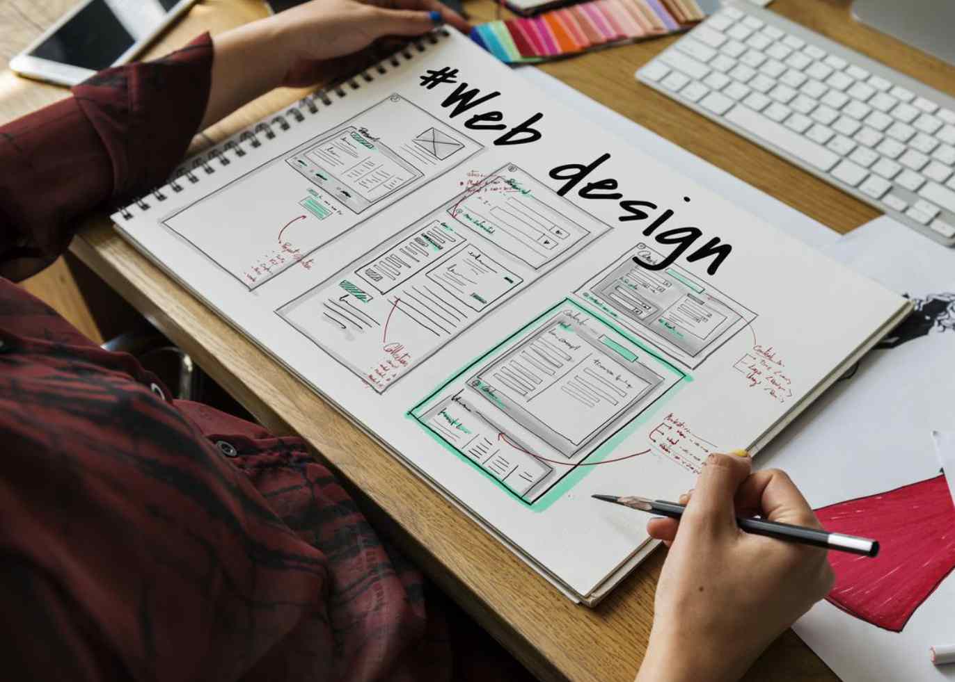 A person sketches a website layout to add to their home builder advertising strategy. 