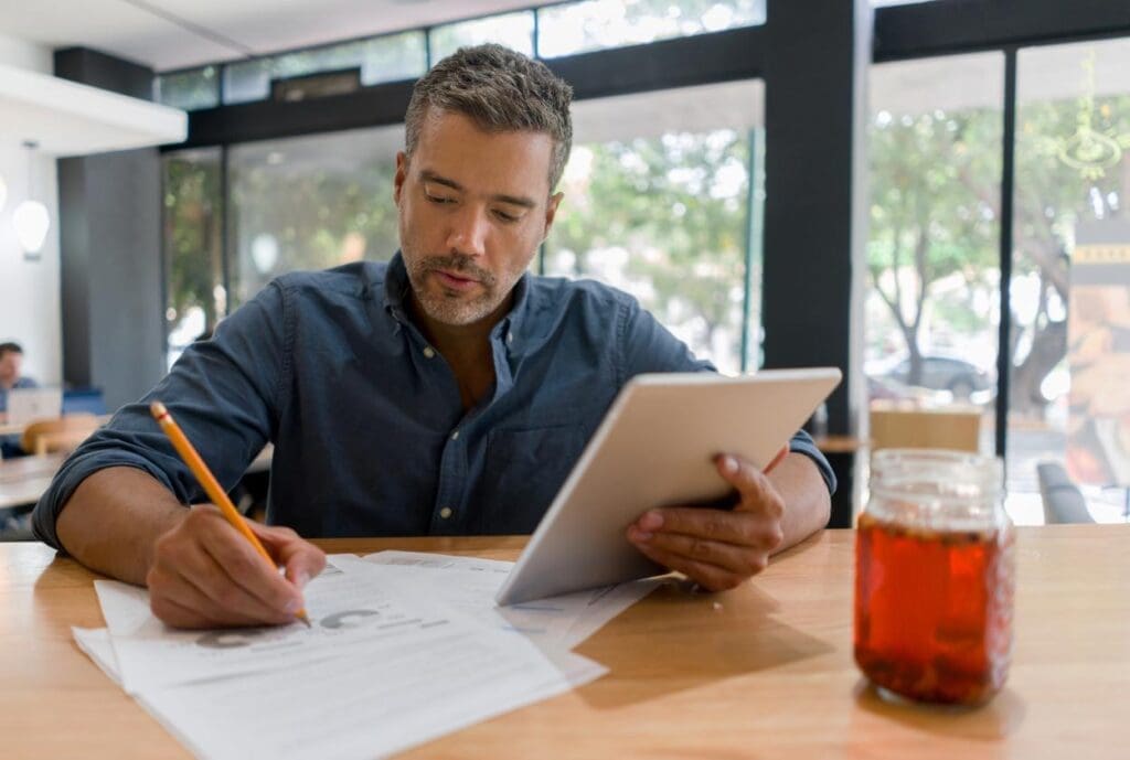 A contractor sits as his desk, working on his home builder business plan.