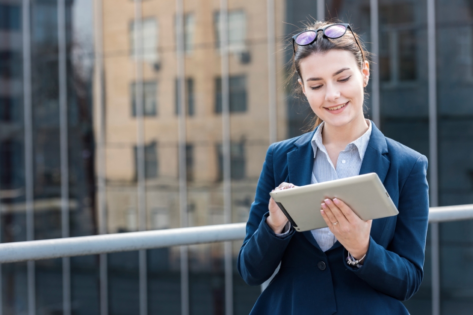Female alumni receives communication on her tablet from her alma mater.