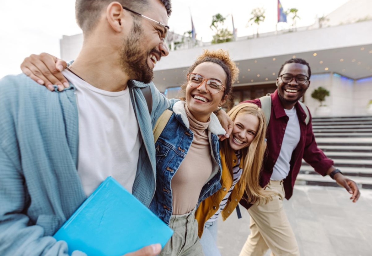 Happy college students walk on campus, having a great student experience.