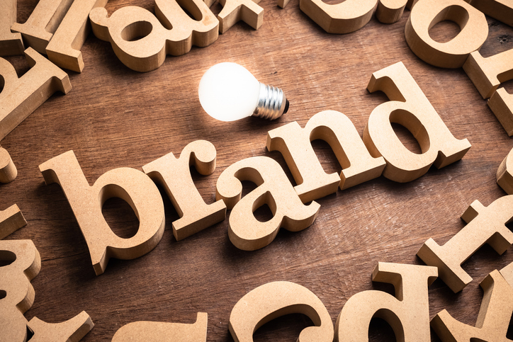 Wood letters spell "brand" with lightbulb next to the word.