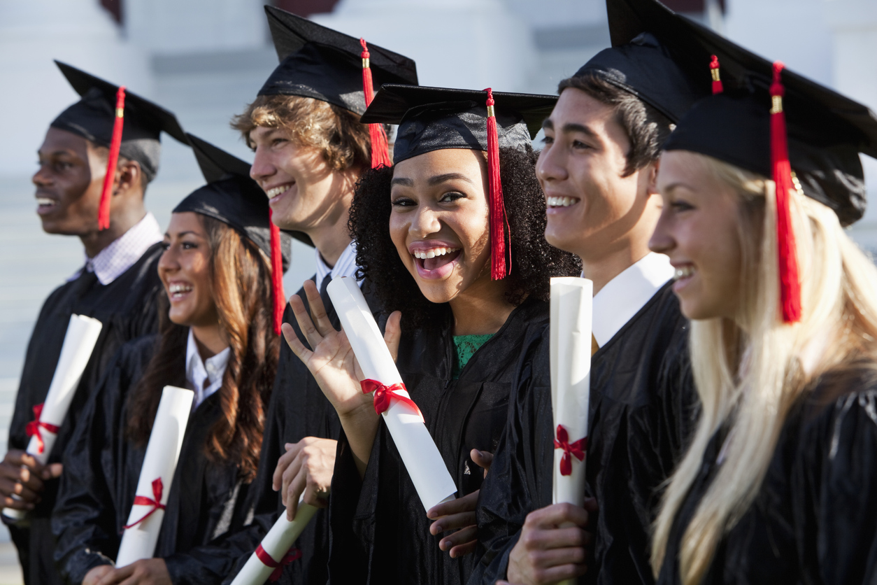 Diverse group of college students in their cap and gown at graduation. 