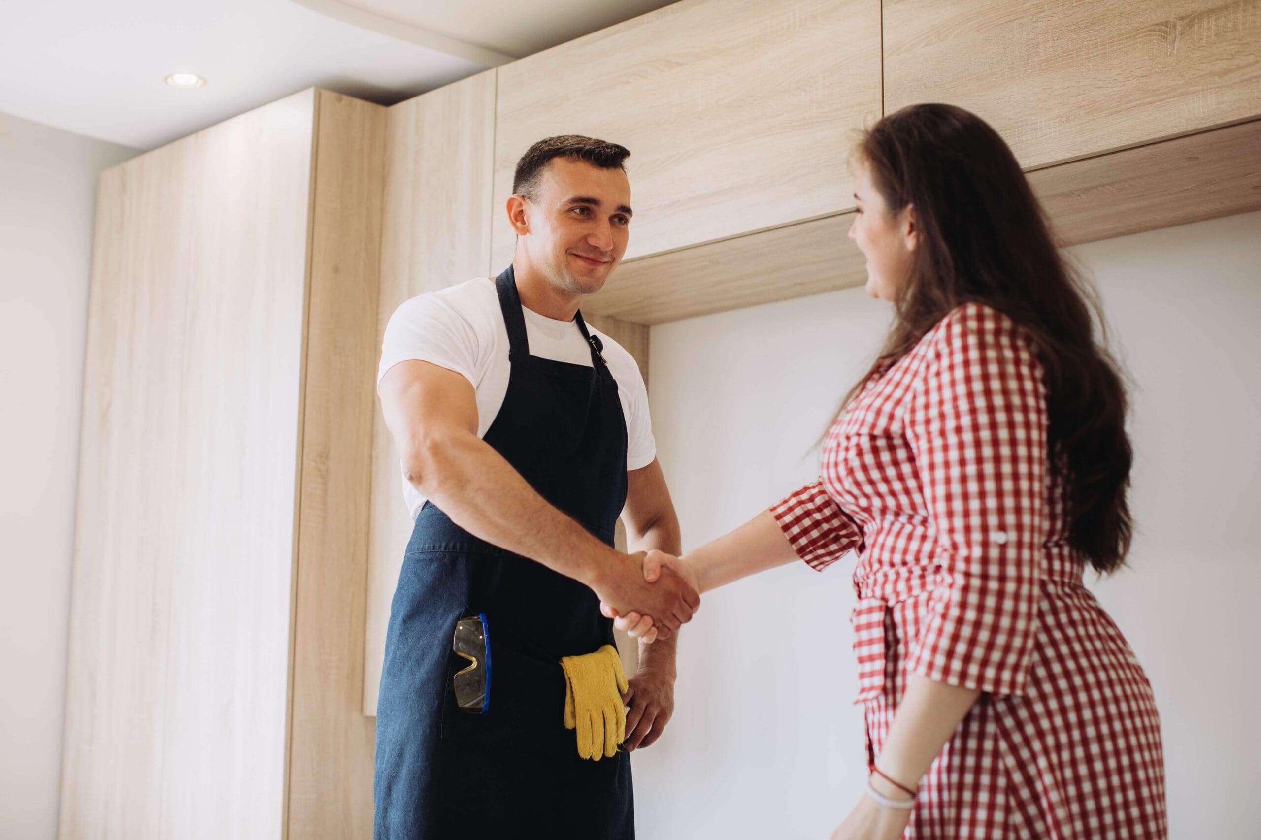 Home services employee shaking hands with homeowner