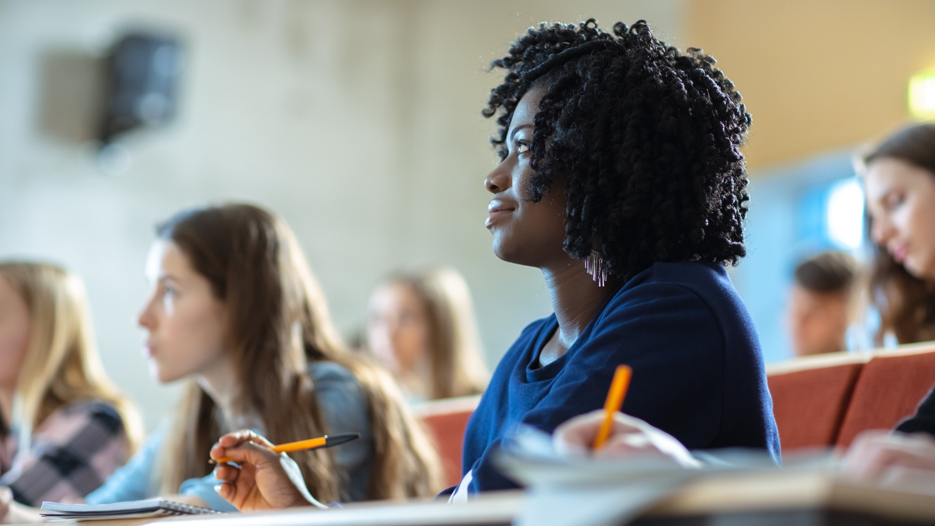 A graduate student pays attention in class.