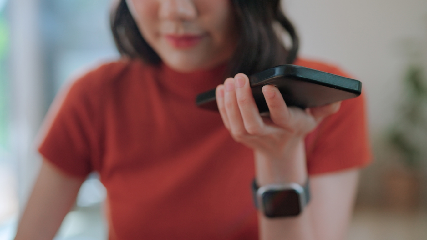 Woman uses phone to talk to a multilingual chatbot