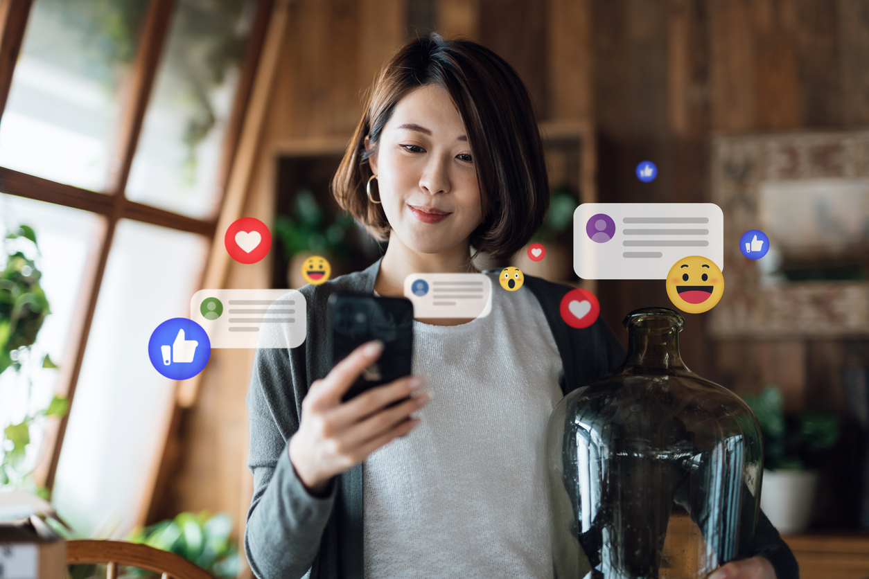 A woman uses her phone to react to social media posts, leaving social proof for others to see.