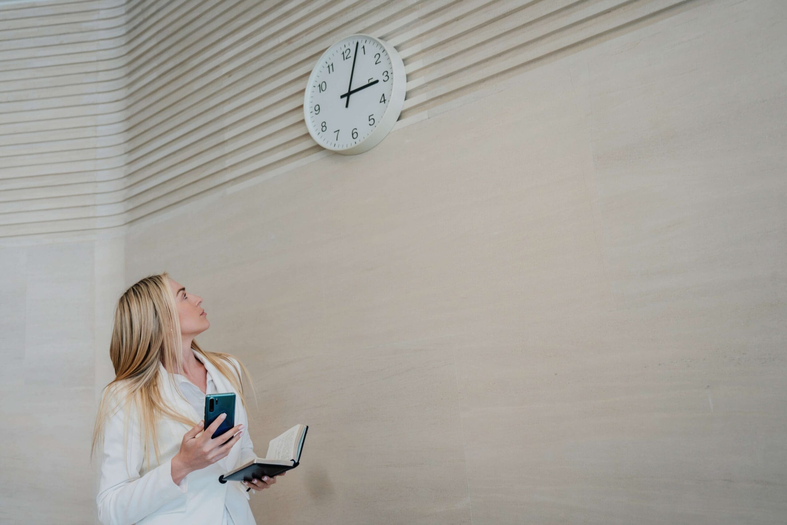 Businesswoman looks up at clock, symbolizing speed to lead