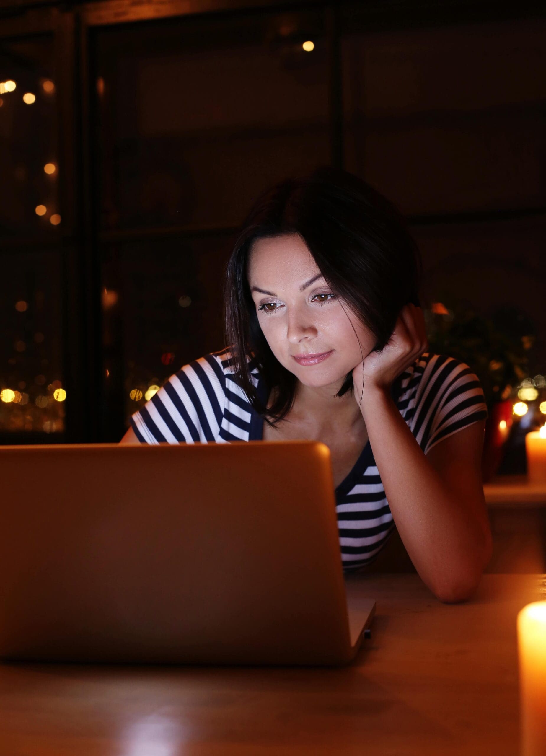 Woman browsing on her laptop at night