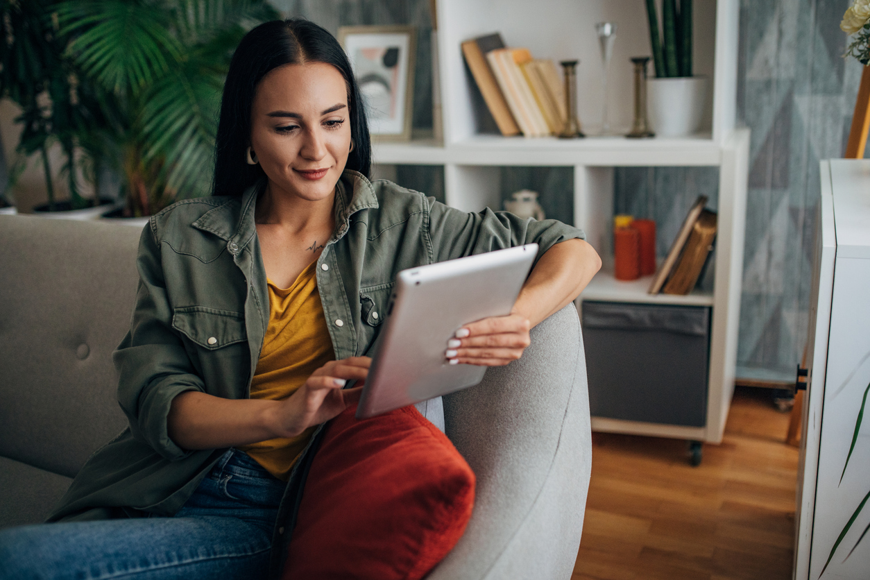 Woman uses her tablet to shop for a new home, while AI gathers data about what she's interested in.