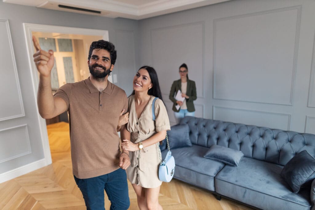 Happy couple looks at the living room of a new home, built using new homebuilding trends.