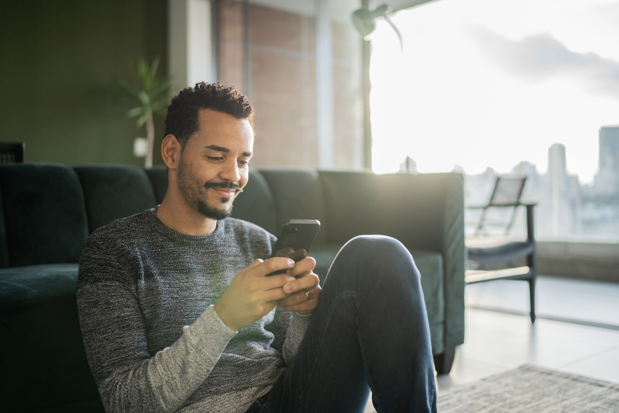 Man sits on floor with phone, getting immediate response through AI SDR.