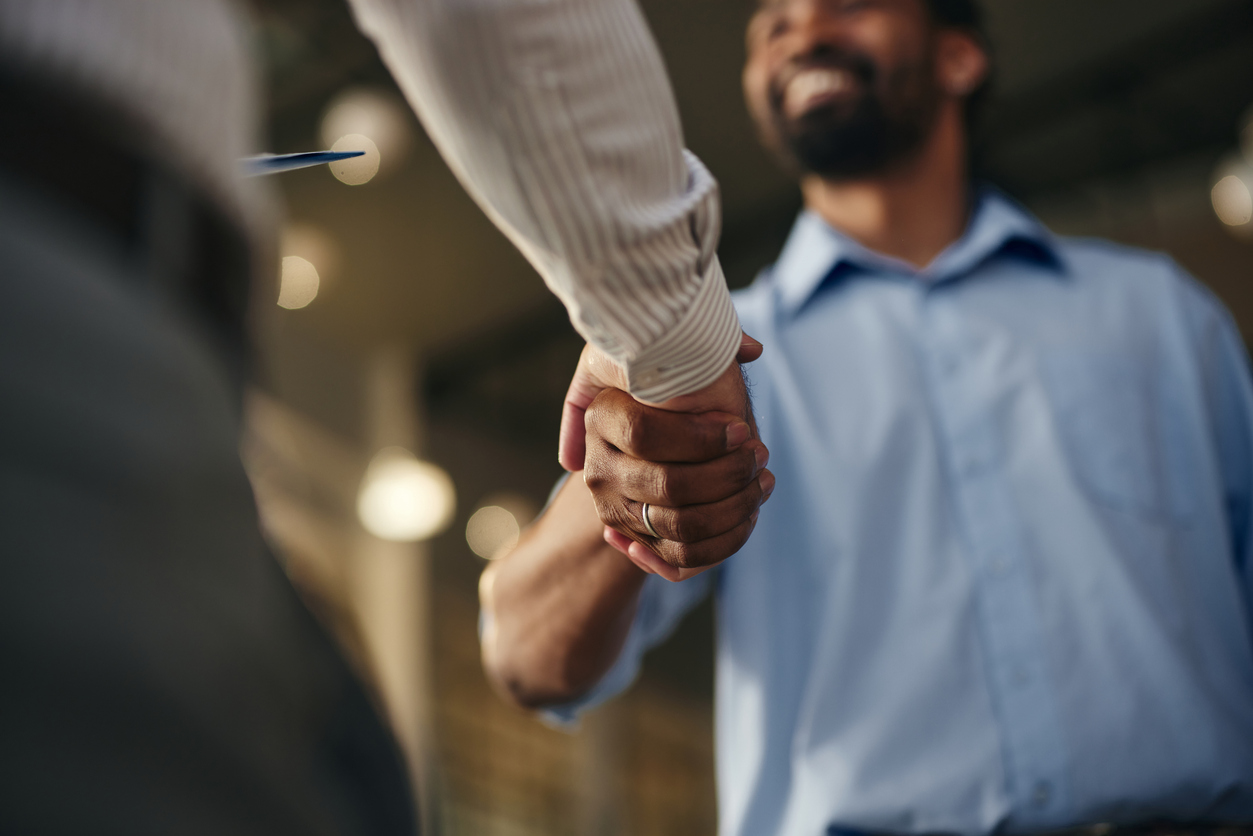 Two people shake hands, closing a deal, illustrating the importance of knowing how to qualify leads faster.