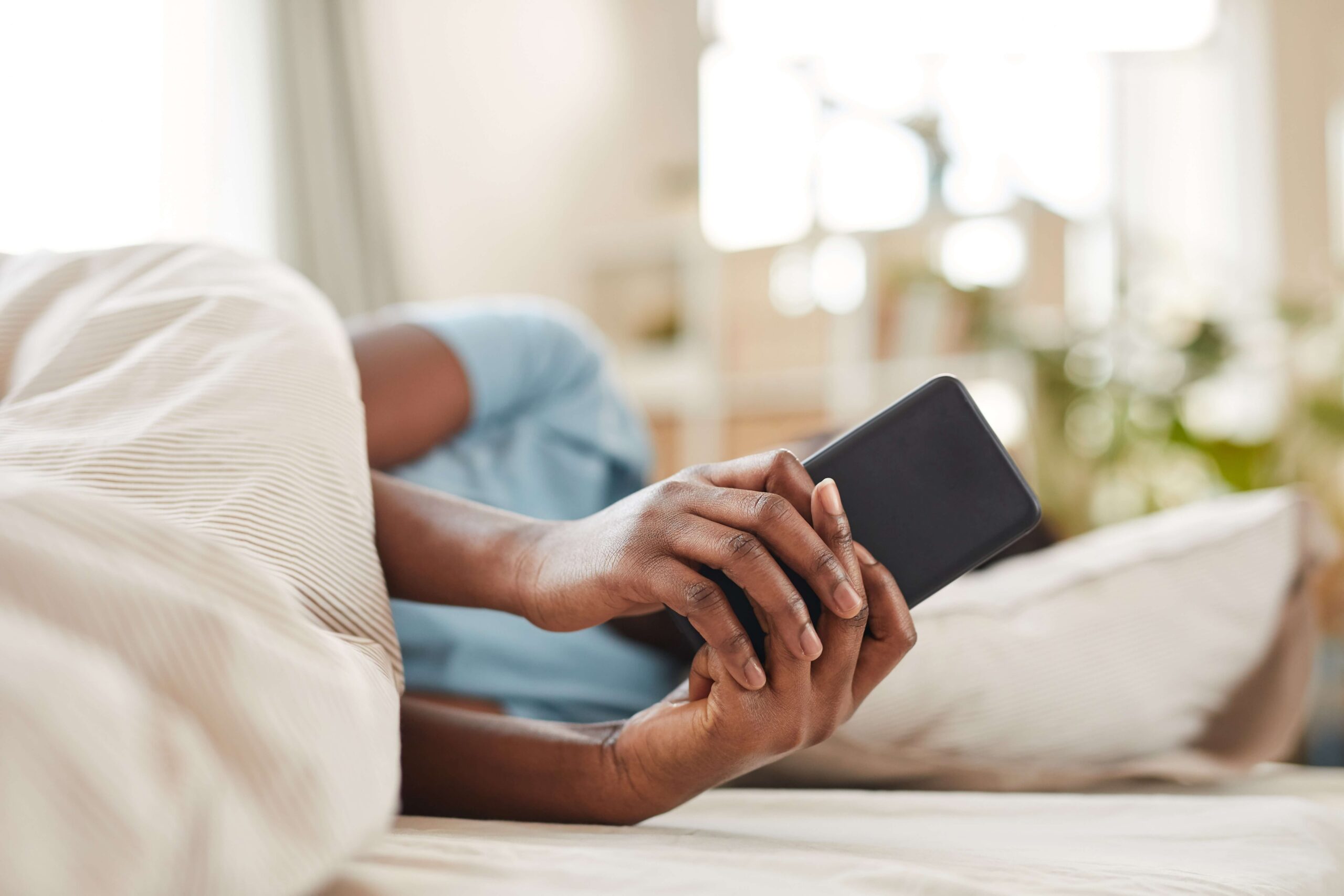 Person checking phone in bed
