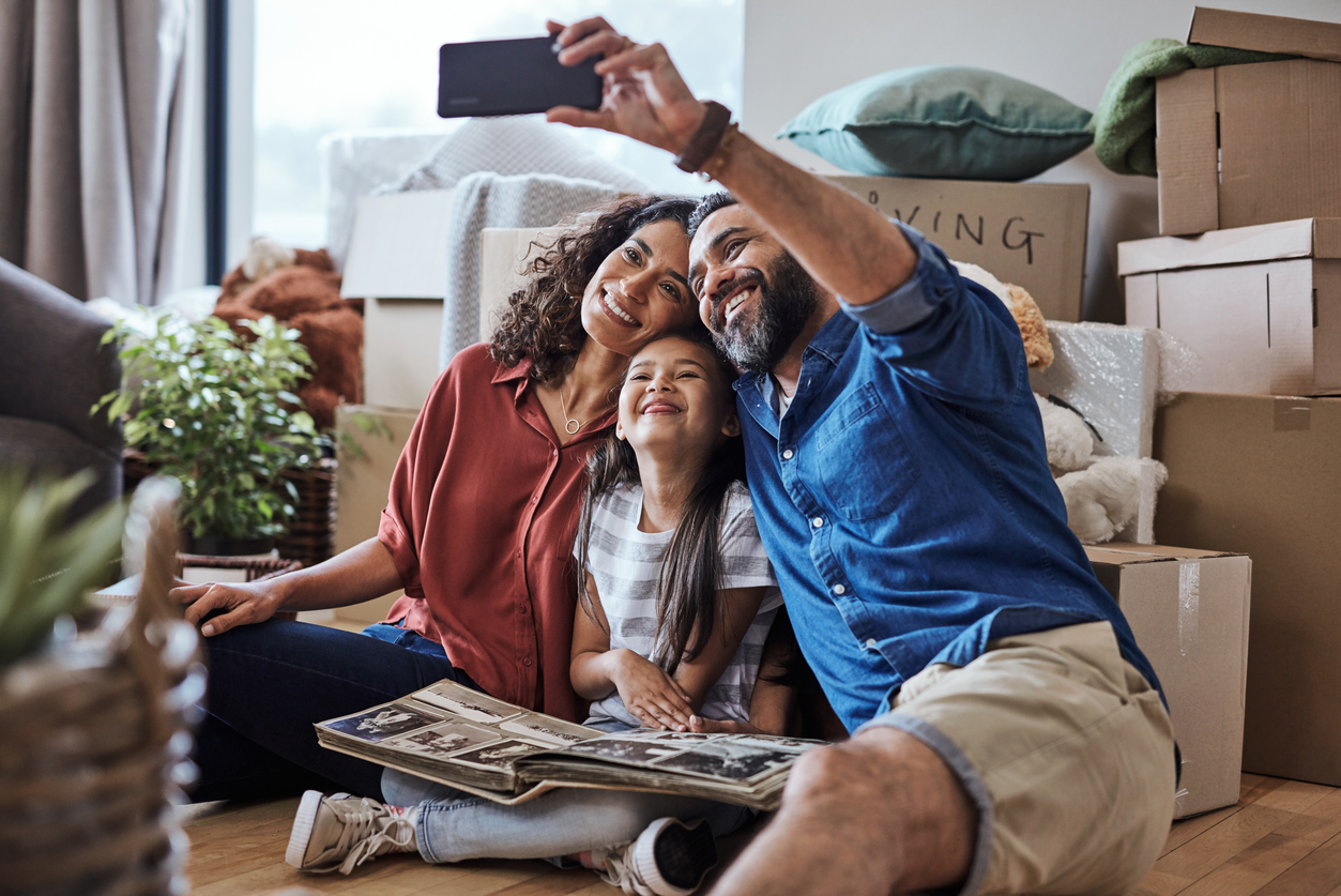 A family takes a selfie as they unpack in their new home, illustrating the importance of AI to human handoff in conversion. 