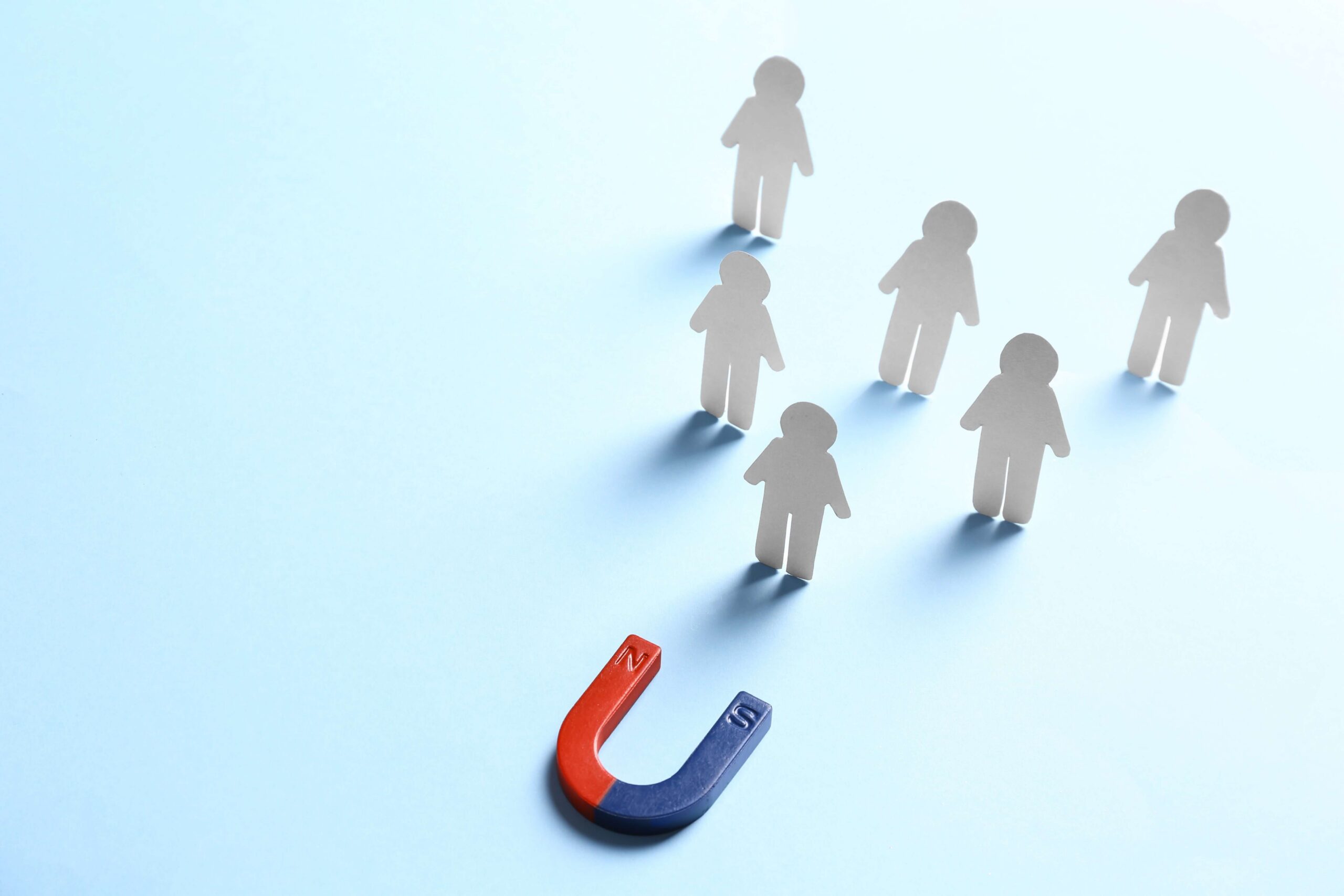 People drawn to a magnet, representing lead generation and nurture