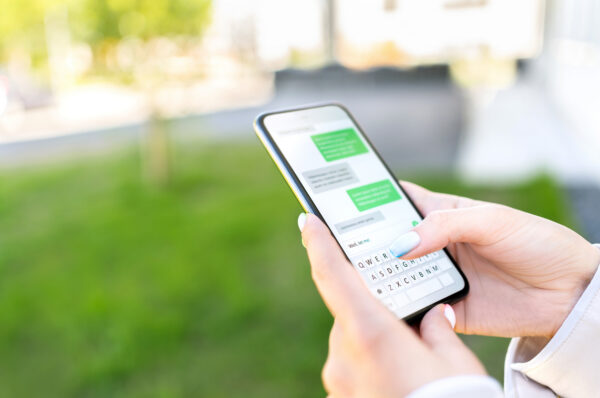Woman has an SMS conversation with a brand on her phone, illustrating the shift to conversational SMS.