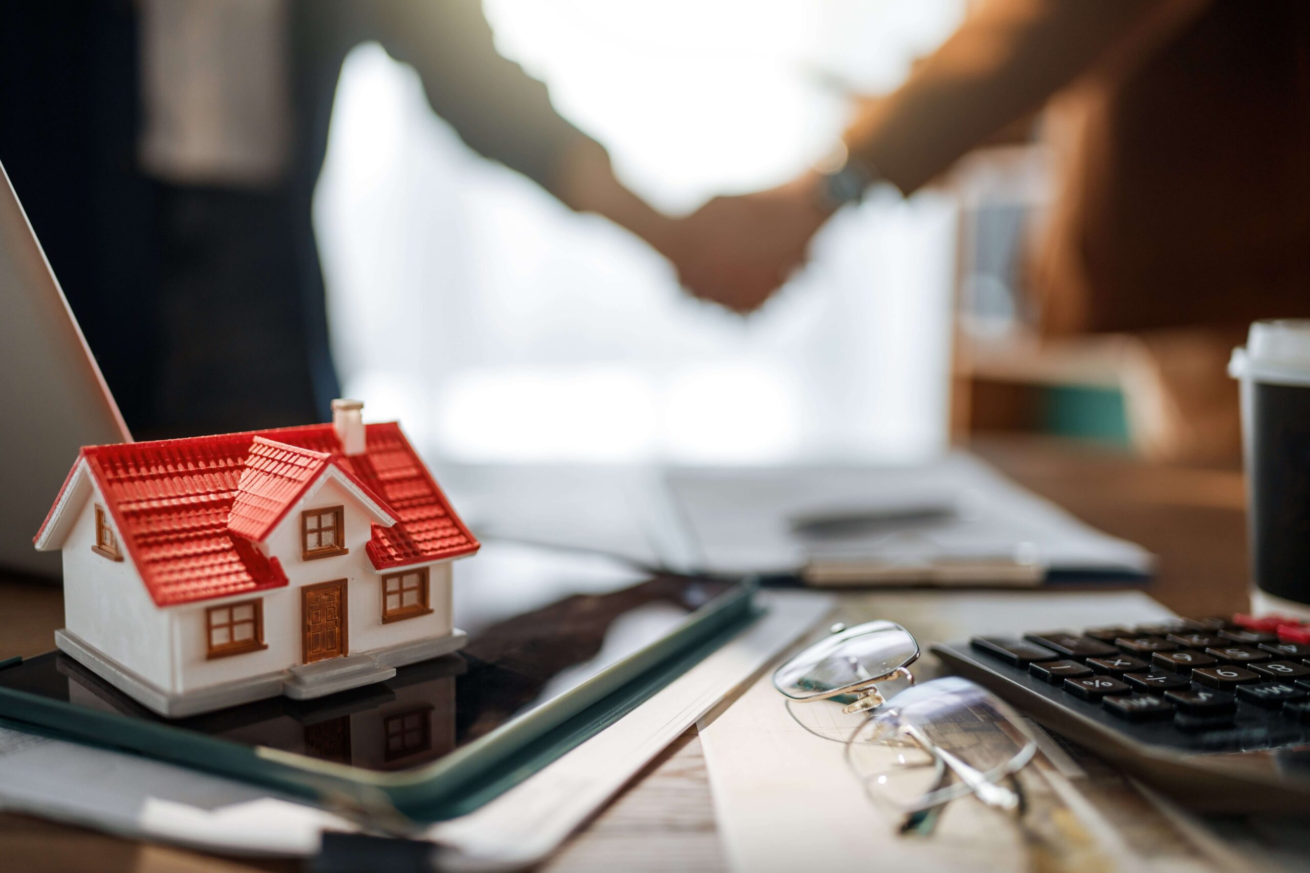 Mortgage appointment set by AI: model home in the foreground with a handshake in the background