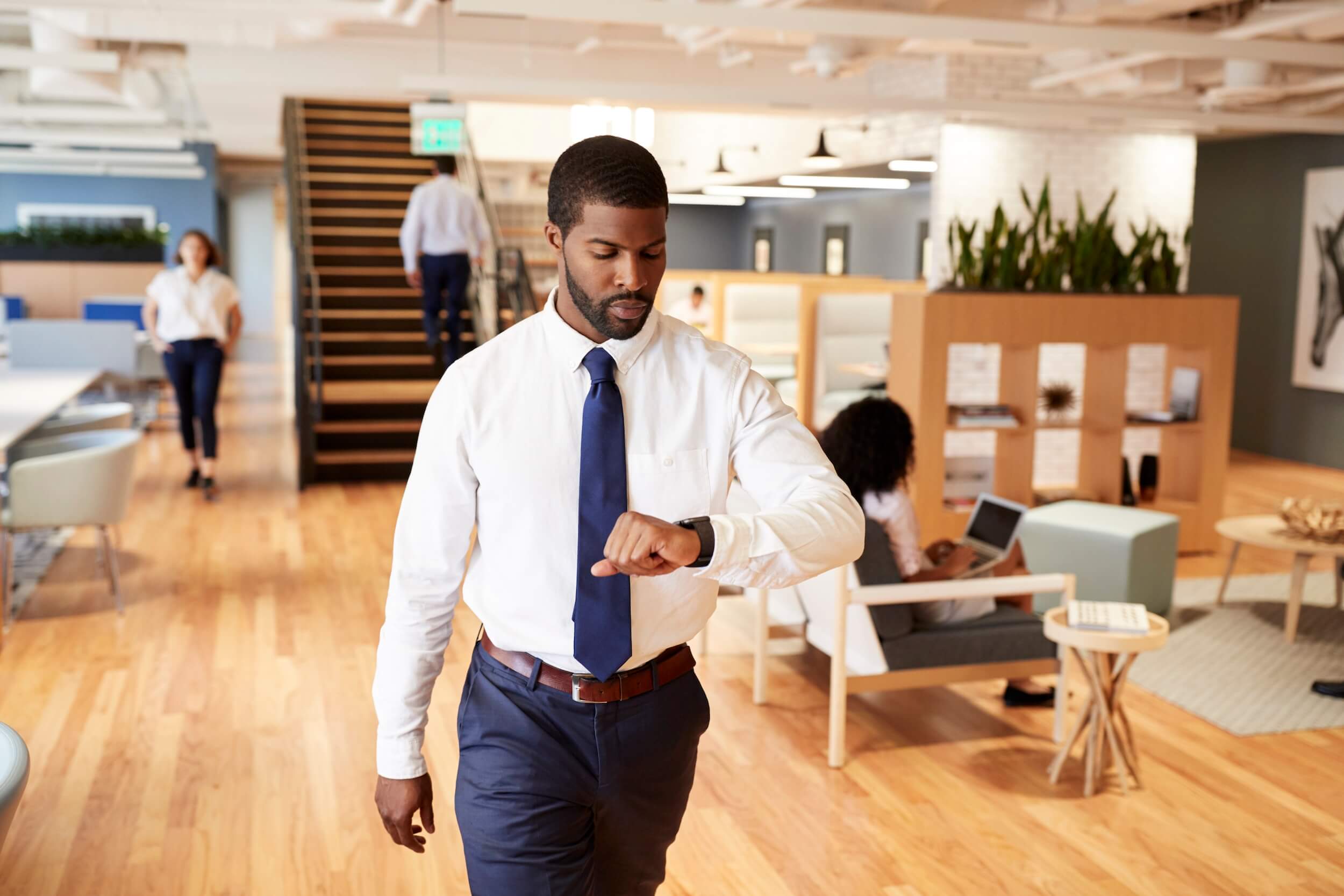 Sales professional walks through busy office